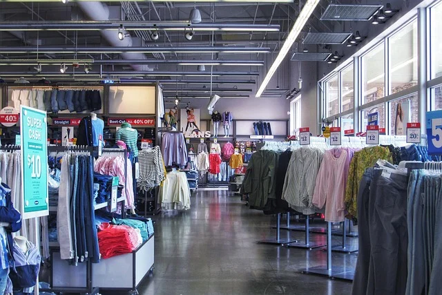 Racks of clothes and promotional discount signs inside a retail store
