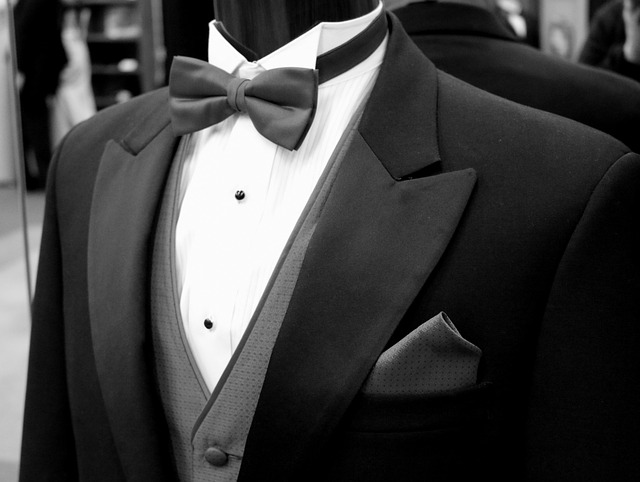 Tailor hand-stitching a lapel on a bespoke suit during a fitting