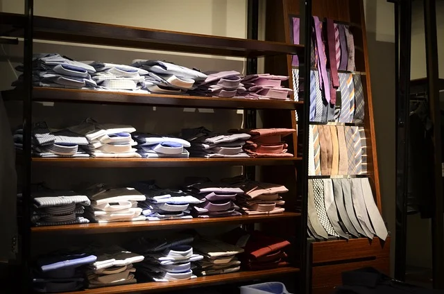 Folded dress shirts and neckties displayed on wooden shelves
