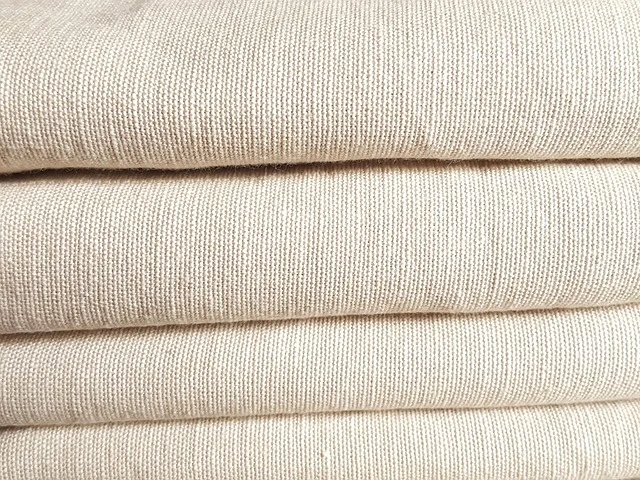 Close-up of stacked beige woven linen fabric