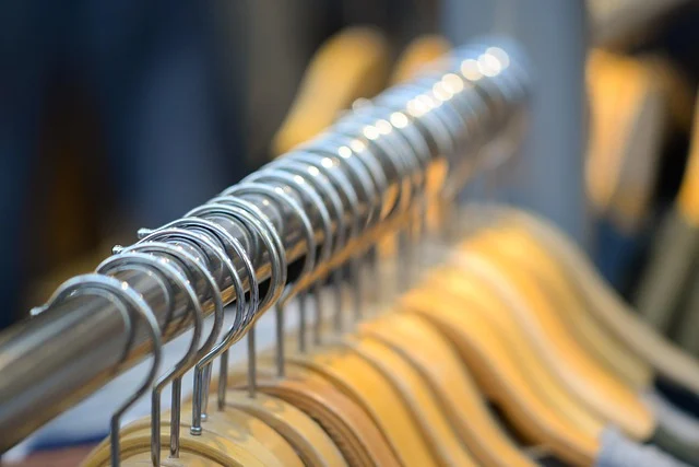 A row of wooden clothes hangers on a metal rack
