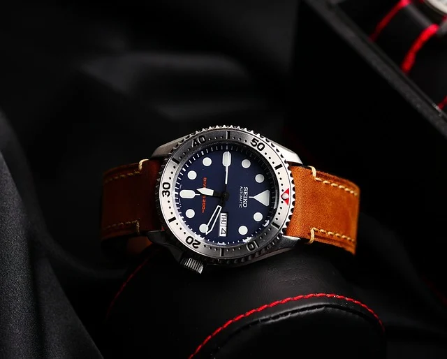 A Seiko wristwatch with a brown leather strap on a watch stand