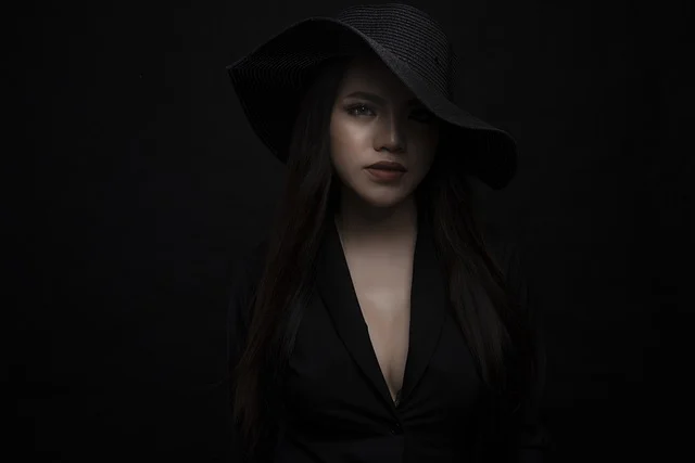 Portrait of a woman wearing a black hat and elegant black outfit