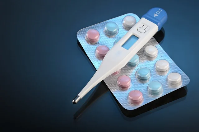 A digital thermometer on a blister pack of pills