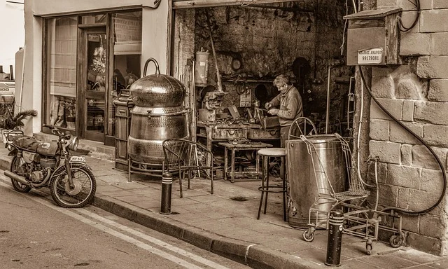 A craftsman working in a traditional metal workshop on a street