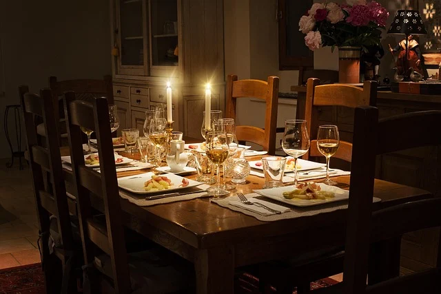 A dining table set with food, wine glasses, and lit candles