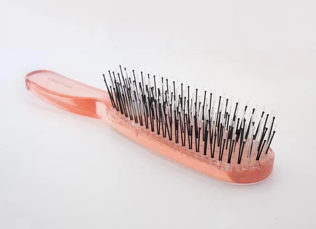 A pink hairbrush on a white background