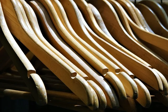 A close-up row of empty wooden clothes hangers