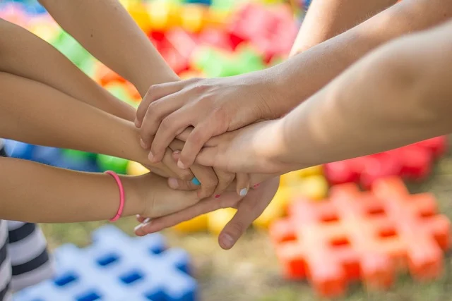 Multiple hands stacked together showing unity and support