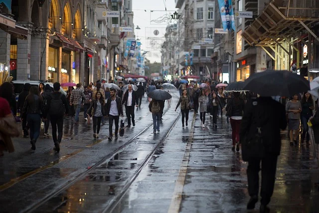 People walking with umbrellas on a wet city street in the rain