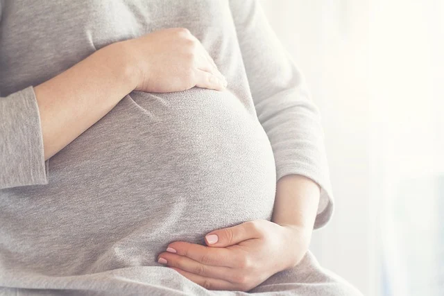 A pregnant woman holding her belly
