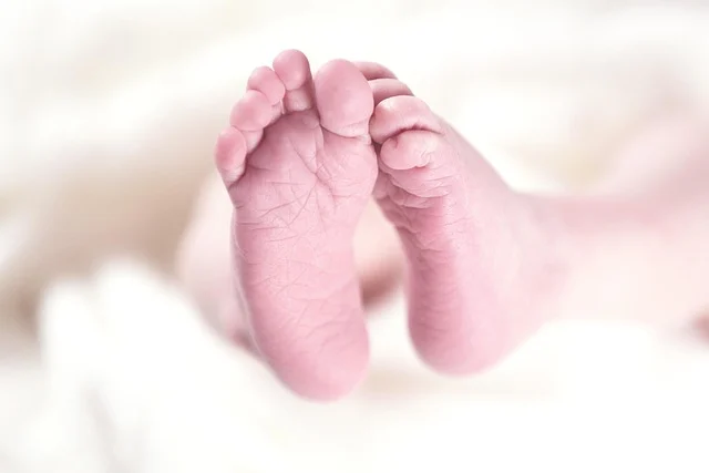 Close-up of tiny newborn baby feet on a soft blanket