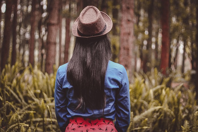 Woman layering a denim jacket over a floral sunlight dress