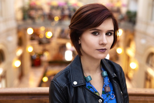 Woman with a short, textured pixie cut smiling outdoors