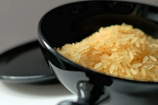 Uncooked rice grains in a black bowl