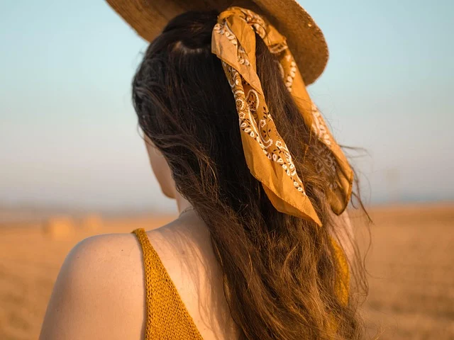 Woman from behind with a yellow patterned bandana tied in her hair