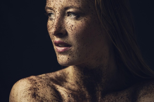 A woman with a brown scrub applied to her face and skin