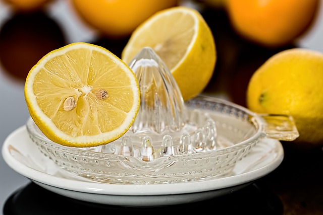 Fresh halved lemons and a glass manual citrus juicer