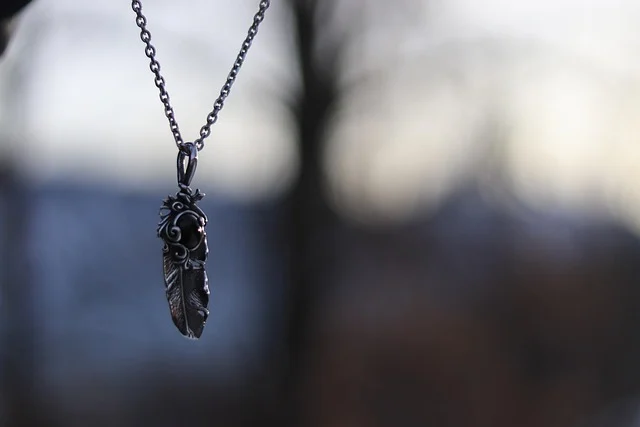A silver feather pendant necklace on a chain