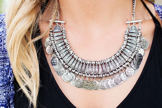 A woman wearing an intricate silver statement necklace