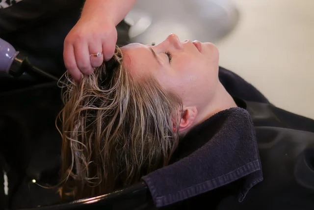 woman washing hair thoroughly in shower after hair oiling